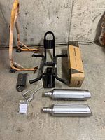 All items in lot laid out: chock, stand, mufflers, lever, bracket