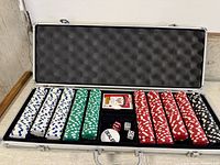Open aluminum case showing poker chips, cards, dice, dealer button
