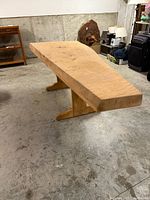 Wide view of redwood slab table with trestle base