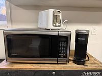 Microwave, toaster and coffee maker grouped on countertop