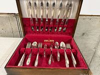 Overall flatware set in wooden chest showing piece arrangement