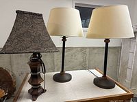 Two matching modern lamps and one traditional lamp on table