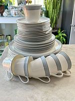 Stack of plates and cups showing pattern, counts not fully visible