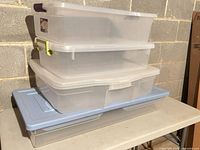 Stack of four storage bins showing relative sizes and lids
