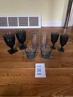 All eight blue glass pieces grouped on floor with lot card visible