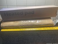 Box labeled "Heated pad" with rolled tan pad