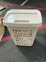 closed hamper front view showing ventilation holes and lid tag