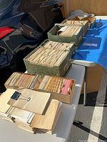 Seven cardboard index card boxes and clipped stack on tables