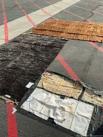 Overview showing both shag rugs and several linens spread on ground