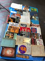 Overview of entire lot showing approximately 30 mixed-language books; titles The Thorn Birds, Pablo Neruda Memoirs, Henri Troyat volume visible