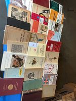 Group view of first 28 books laid flat showing titles, bindings and condition