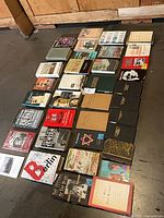 Overview of all approximately 38 books laid out on floor showing bindings and dust jackets
