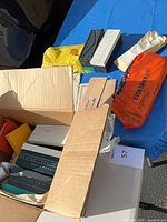 Open box showing multiple slide trays, envelopes, plastic bags