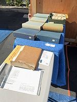 overview of six archival boxes and two card trays on tables