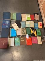 Full overhead view showing all ~30 books laid out on floor