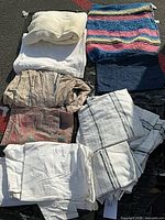 All eight linens folded together on ground