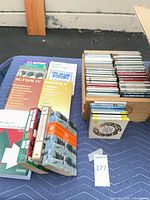 Overall view showing paperback books stack, CDs in wooden box