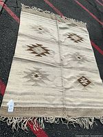 Full view of the flatweave rug showing pattern, fringe, overall wear