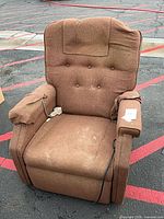Front view of brown power recliner showing seat, tufted back, wired hand control