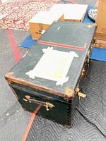 Trunk closed showing overall appearance, dark green paint, red stripe, brass corners, side handle