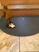 statue on blue semicircle rug