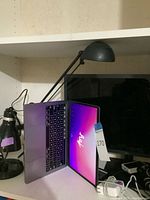 MacBook open beside LG monitor on desk, cables visible