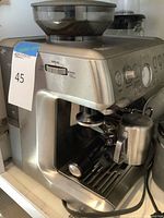 Full view of Breville Barista Express showing body, bean hopper, drip tray and accessories