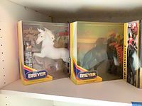 White unicorn and dark horse boxed models on shelf