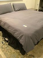 King bed fully made with gray bedding