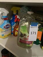 Various spray bottles and Kaytee nectar bottle on shelf