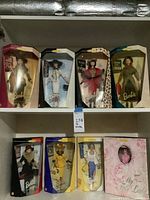 All eight boxed Barbie dolls on shelves showing fronts of boxes and outfits