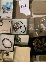 Assortment in boxes including abalone necklace, earrings, rings on velvet, charm bracelet partially visible