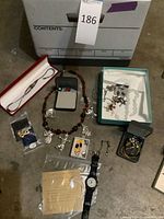 Full lot overview showing watch, necklaces, earrings, boxes and packet