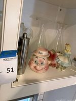 Shelf view showing jam jar, Alice planter, stainless shaker, two glass decanters