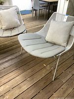 Both metal mesh patio lounge chairs with cushions on deck
