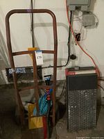 Shows steel hand truck, assorted cleaning tools and box of tiles