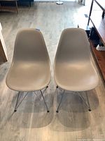 Front view of both taupe Eames side chairs on chrome Eiffel bases