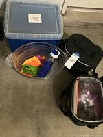 Overall lot showing blue bin, clear tub, coolers