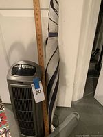 Grouped view of tower fan, yardstick, umbrella, draft protector