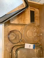 Drawer view showing Circulon pan, cutting boards, mixing bowl, measuring cup, and nested baking dishes