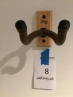 Front view of mounted guitar hanger showing full construction