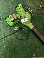 Leaf blower with charger and battery displayed on floor