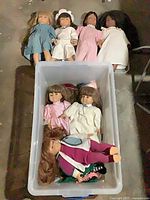 All seven dolls shown inside and atop a storage bin