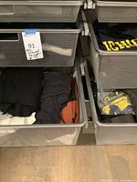 Mesh drawers showing folded sweatshirts, t-shirts and shorts