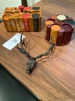 Overview of both poker chip sets and metal deer skull on table