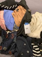 Overview of all sweaters inside black zip tote