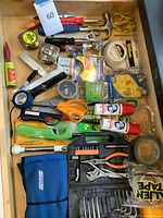 Full drawer overview showing variety of tools, tapes, adhesives and hardware