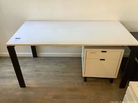 Full view of white desk with cabinet under right side