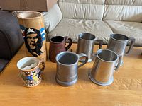 Group shot of all seven beer mugs on table