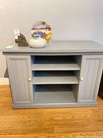 Front view of grey cabinet showing two doors and central shelves